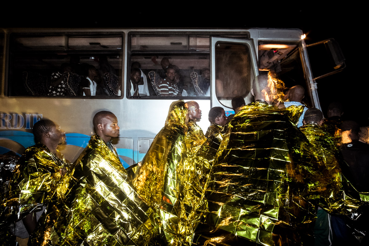 28/08/2016, Lampedusa (Italy). In the island's harbour, some of the 240 migrants rescued at sea by the Italian Coast Guard board a bus that will take them to the island' reception centre for migrants.